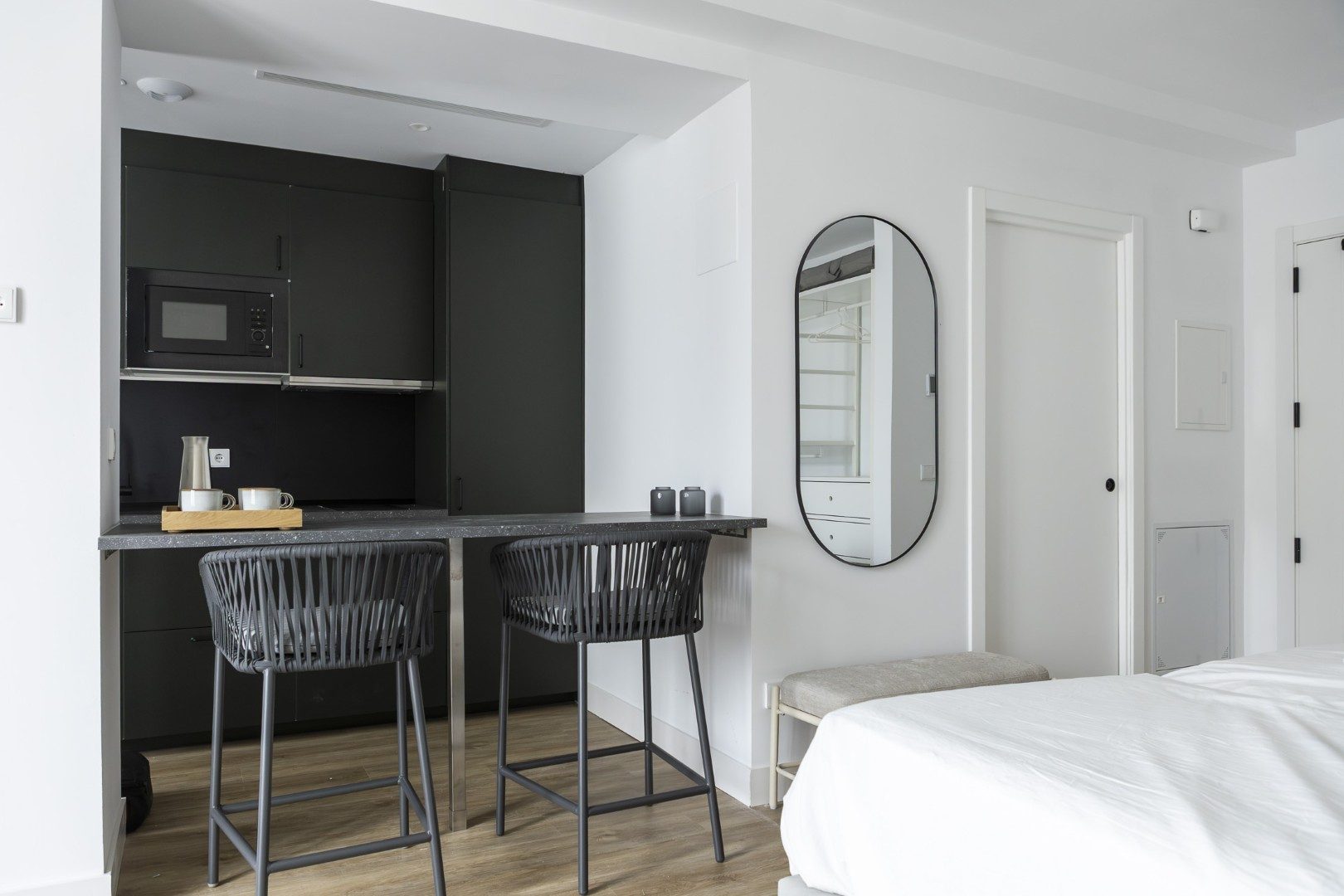 Estudio boutique Cauce4 con cocina equipada, barra con taburetes y zona de descanso